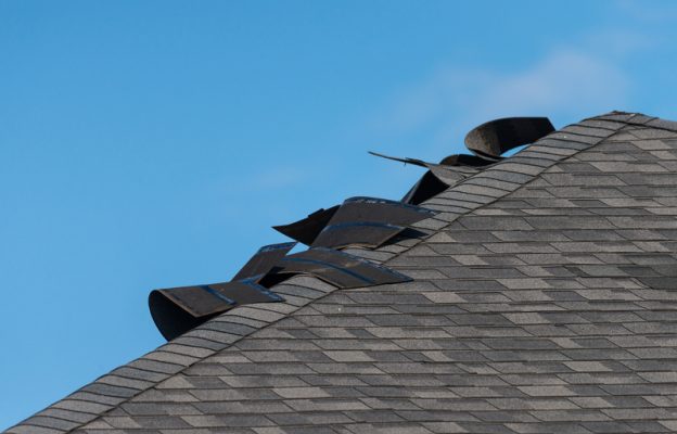 Edge of a residential roof showing significant damage
