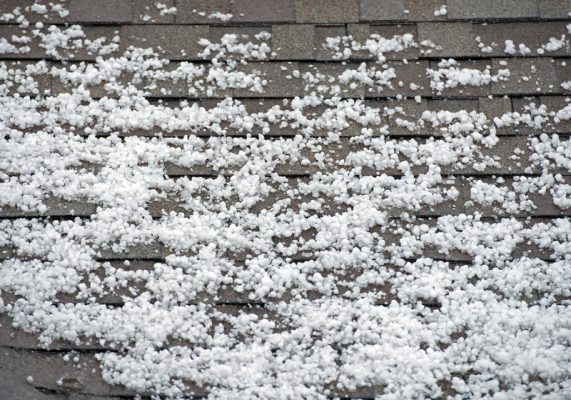 pieces of hail accumulating on the top of a roof