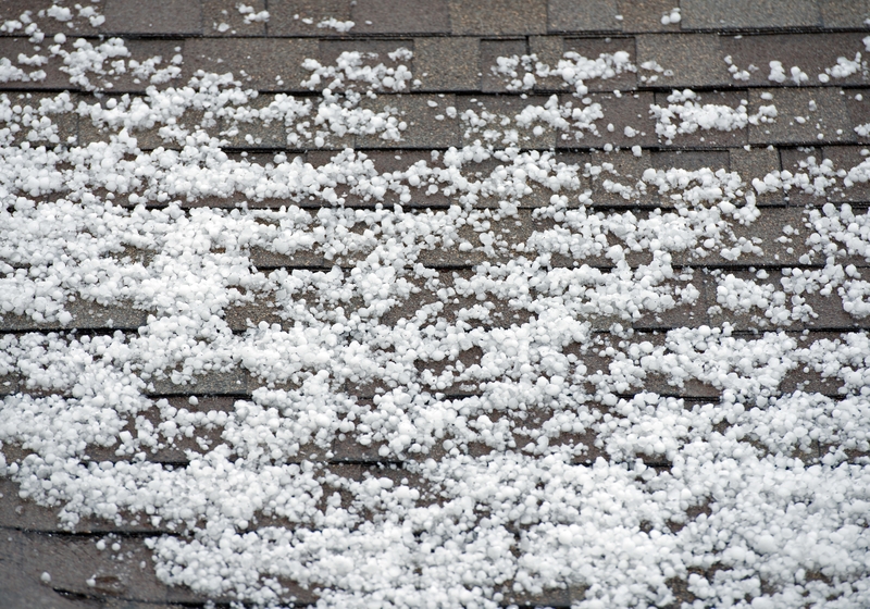 pieces of hail accumulating on the top of a roof